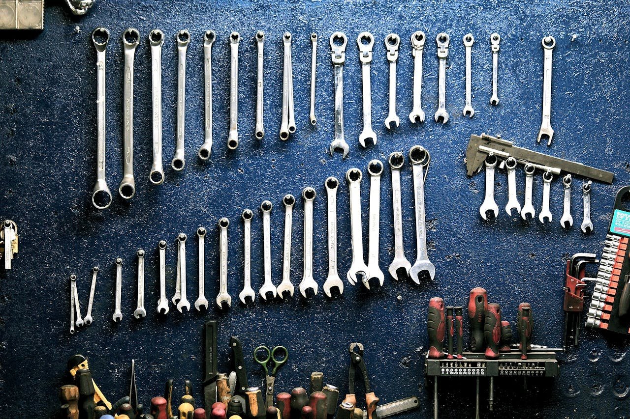 Why Regular Vehicle Maintenance Saves You Money in the Long Run Neatly arranged wrenches and tools on a workshop wall, ideal for mechanics.